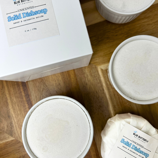 Solid dish soap bars on a wooden surface with packaging.